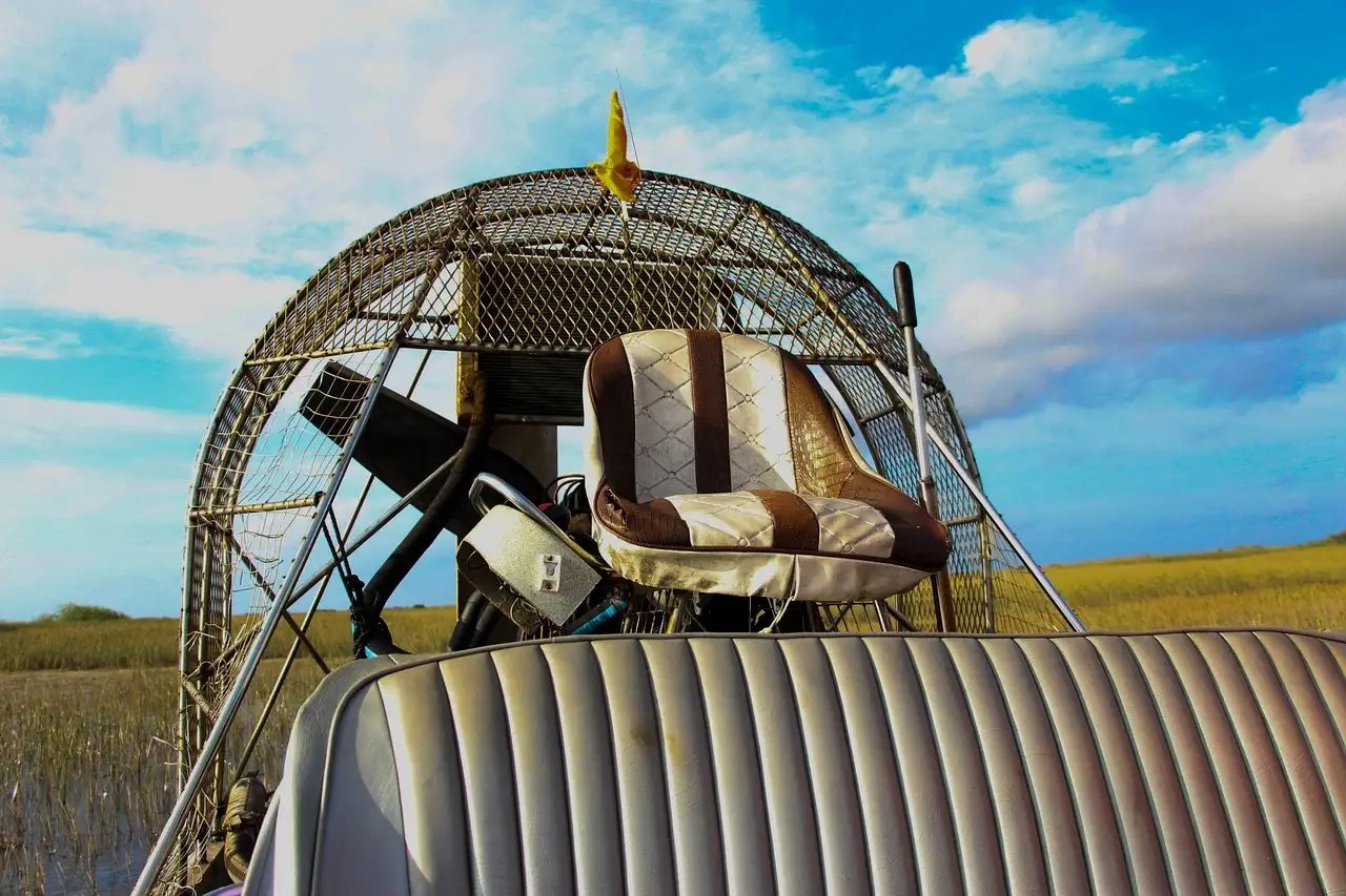 An airboat's raised seat and fan cage, with marsh grass behind