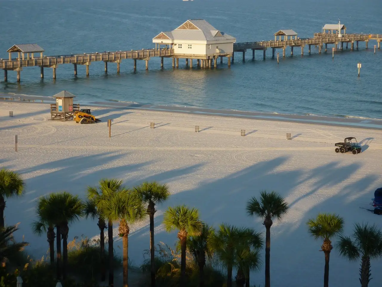 Clearwater Beach's white sand and palms, with a long pier on the water