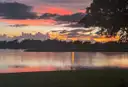 Sunset over a calm Florida lake with trees on the far shore