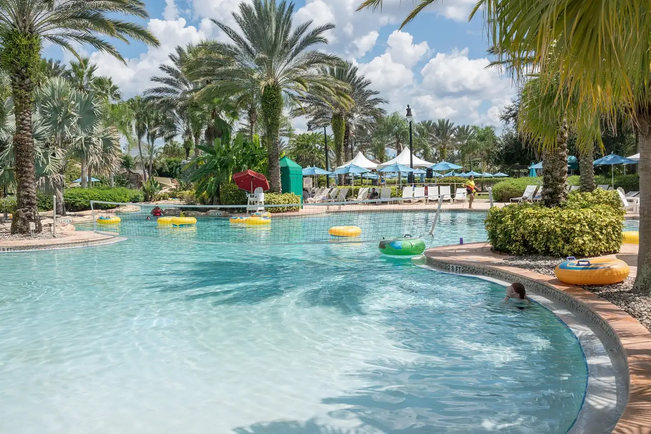 A winding pool and lazy river with palm trees and sun loungers in Florida