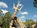 A giant stone hand holding a trident in Islands of Adventure, under a blue sky