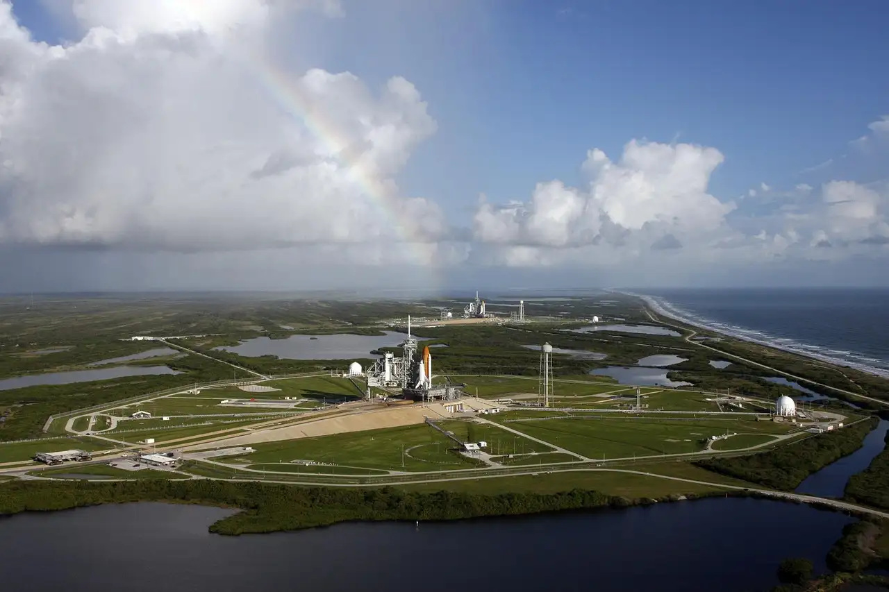 An aerial view of a launch pad by the coast, with green marsh around it