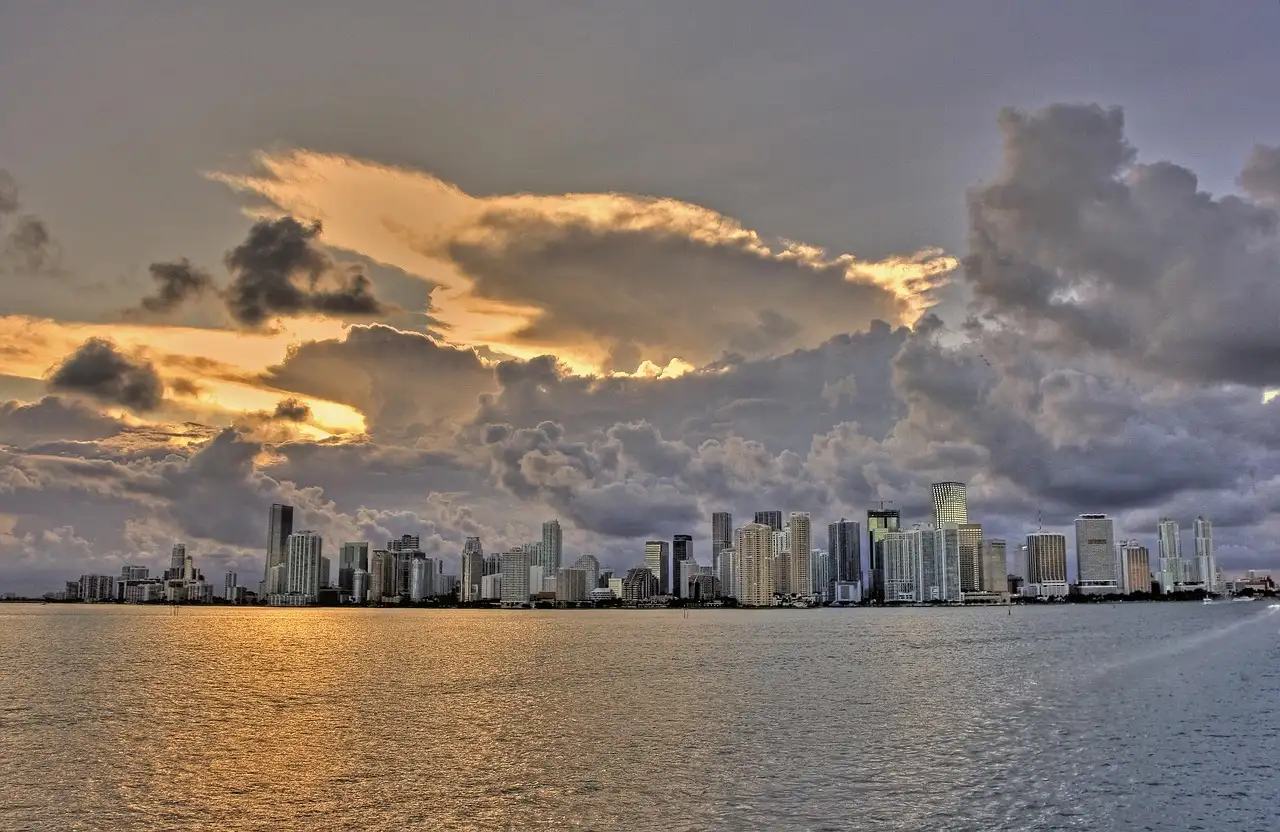 The Miami skyline across the water at sunset under heavy clouds