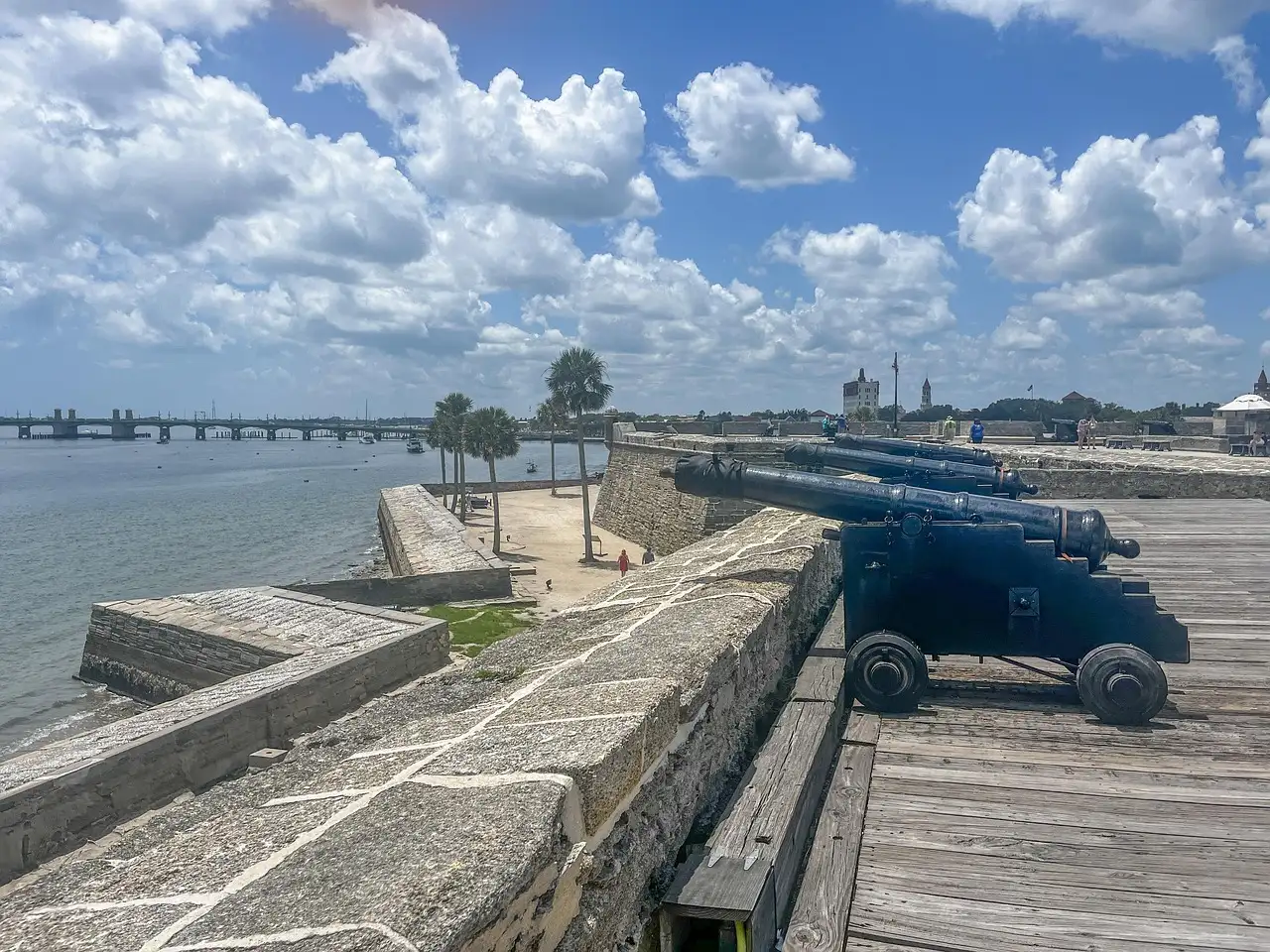 Old cannons on the stone wall of St. Augustine's fort, with the bay behind