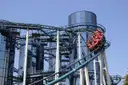 A roller coaster train leaning through a tight steel curve